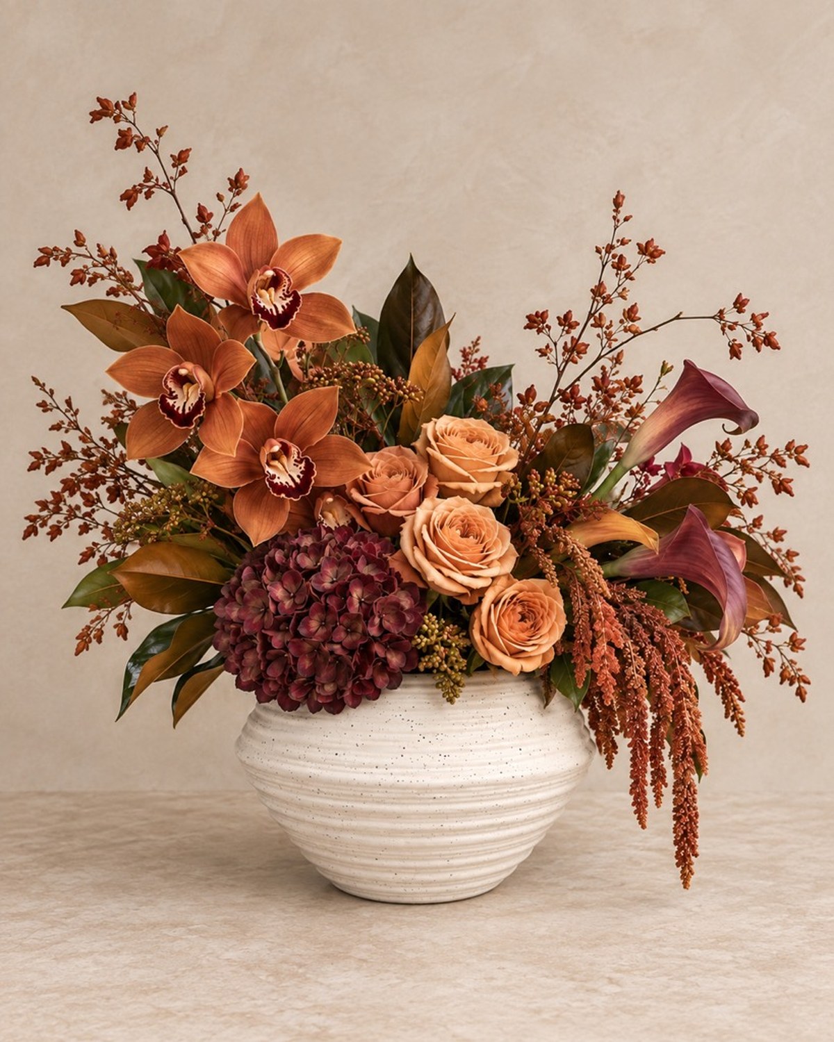 A white ribbed vase with rust dahlias, cream blooms and trailing amaranthus branches.
